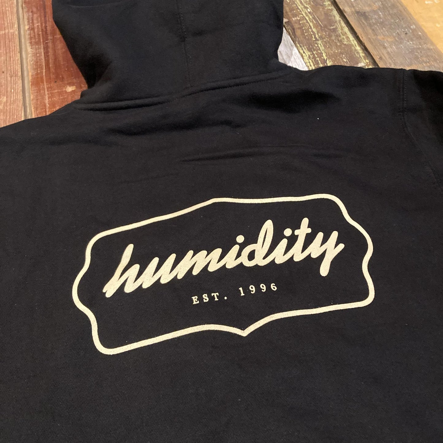 Humidity Badge Hoodie with the cream color badge