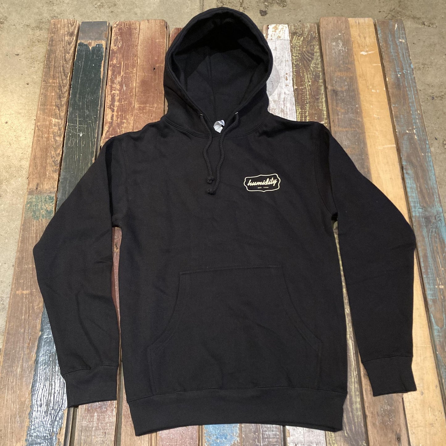 Humidity Badge Hoodie with the cream color badge