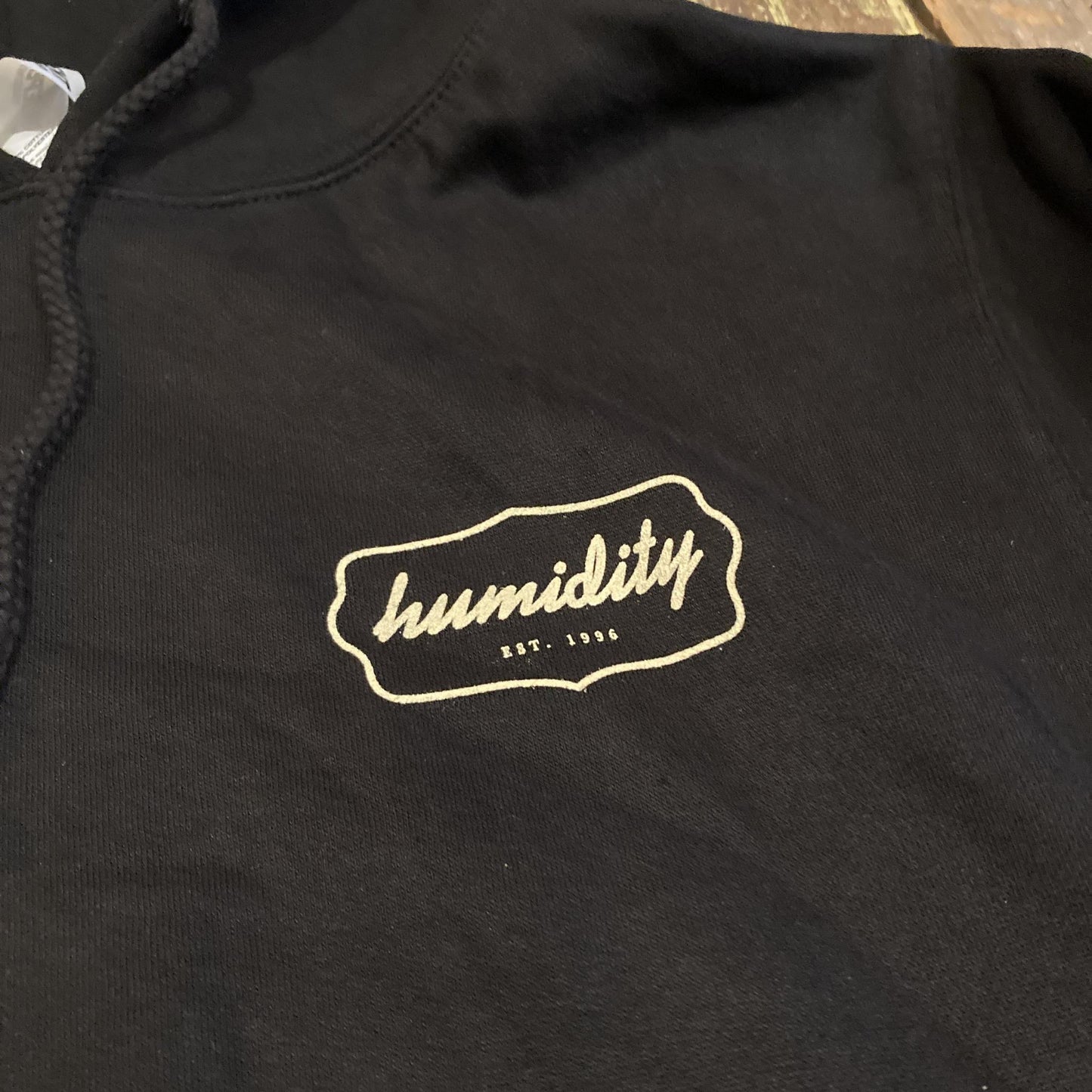 Humidity Badge Hoodie with the cream color badge